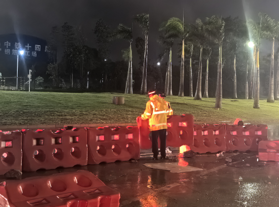 机场交警冒雨恢复隔离水马桩的正常摆放，保障道路畅通